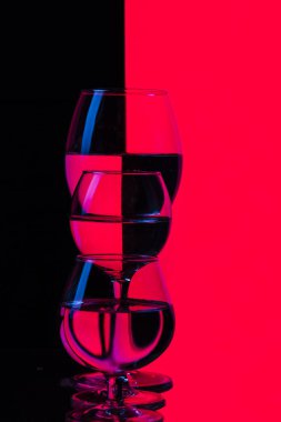 Glassware Kavramları. Siyah ve Kızıl Arkaplan 'a karşı tek sıra halinde yerleştirilmiş üç farklı cam bardak. Dikey Bileşim