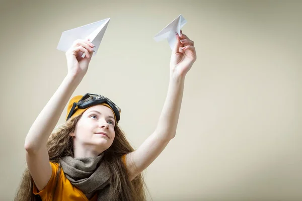 Portrait of Cheerful Caucasian Girl Holding Two Paper Planes With Pilot Goggles. Horizontal Image Composition