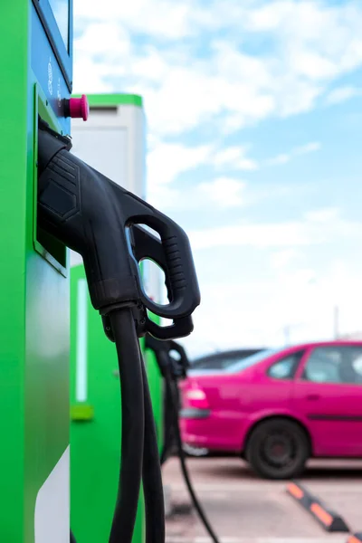 Car Charging At Station With Power Cables  Hanged on Stations. Vertical Image Composition