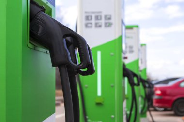 Alternatif Enerji Konsepti. İstasyonda elektrik kablosu takılı elektrikli araba ya da EV araba şarjı. Yatay Resim