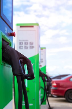 Enerji Konsepti. İstasyonda elektrik kablosu takılı elektrikli araba ya da EV araba şarjı. Dikey Yönlendirme