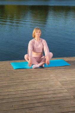 Tahta Sahne 'de, Kapalı Gözler eşliğinde Yoga yaparken Spor Vitesli Kafkas Kadınını Rahatlatmak. Dikey Resim Kompozisyonu