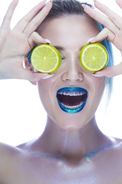 Pürüzsüz Dişli Diş Parlatıcı Giyen Beyaz Kadın. Yeşil kireç elindeyken beyaza karşı poz vermek. Diş Bakımı Ürünlerinizi tanıtıyoruz. Dikey Resim Yönlendirmesi