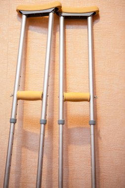 Tıbbi ve Sağlık Konsepti. Duvara Karşı Oturan Engelliler İçin Koltuk değneği. Dikey Resim