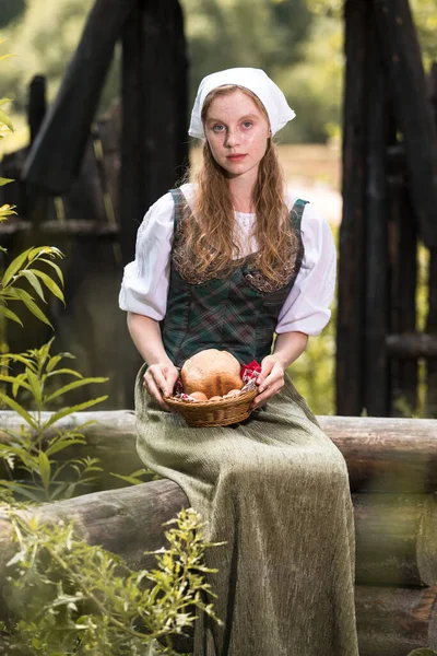 Tahta blokta ev yapımı ekmek sepetli, sakin, beyaz, kızıl, kadın pozu. Dikey Resim Kompozisyonu