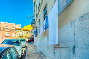 Seyahat Kavramları ve Fikirler. Gündüz vakti Portekiz sokaklarından birinde Renkli Kurutulmuş Çarşaflar Araba Hattı boyunca. Yatay Resim