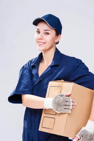 Shipping and Delivery Ideas. Positive Caucasian Female Messenger With One Disptatched Freight of Carton Box Parcel to Addressee on  Gray. Vertical Image