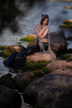 Asyalı Deniz Kızı Deniz Kıyısı Kayalıklarında Ağla Kucaklaşırken Deniz Cehennemi Süslü Taç ve Siyah Parlak Kuyruk Giyinerek Denizlerin Düz Kraliçesi Olarak Korunuyor.