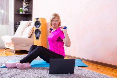 Uzaktan kumandalı internet eğitim seansı sırasında Mavi Mat 'te yoga yapan son sınıf beyaz kadın. Yatay bileşim resmi