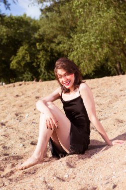 Mutlu Heyecanlı Kafkasyalı Esmer Kız Gündüz vakti Deniz Kıyısındaki Sandy Plajında Dinleniyor. Dikey Oryantasyon