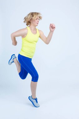 Aktif Koşu Eğitimi sırasında Beyaz Geçmişe Karşı Olgun Sporcu Kadın Koşu. Dikey Yönlendirme