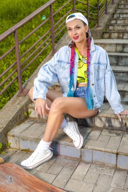 Gülümseyen Hippi Kadın Kaykaycı Merdivenlerde Uzun Tahtayla Poz Veriyor ve Modern Captical Image Kompozisyon Giyiyor