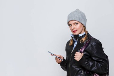 Kafkasyalı sarı şapkalı kız ve cep telefonu ve sırt çantalı deri ceketli. Yatay Resim Kompozisyonu