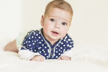 Yeni doğan küçük kız mutlu ve gülümseyerek beyaz