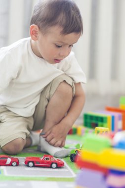 Kapalı oyuncakları ile oynarken küçük beyaz çocuk portresi