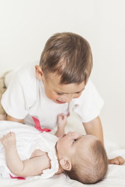 Bebek kız kardeşi ve Smiling.Again ile oynarken küçük şirin çocuk