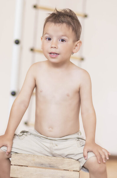 Little Caucasian Boy Sitting In front of Rope Ladder with Positi