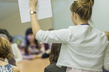 Gro bir kağıt yaprağının ile notlar içinde önünde tutan kadın ev sahibi