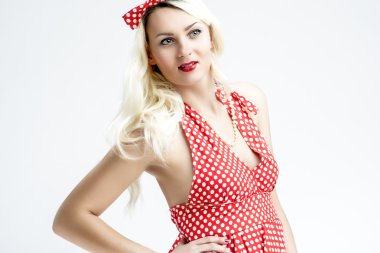 Pinup Style And Concepts. Sensual And Smiling Caucasian Blond Woman In Red Dotted Dress Posing