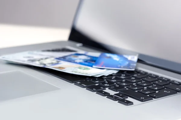 E-Trade and E-Commerce Ideas and Concepts. Stack of Banknotes with Bank Card on Laptop in Front of Open Screen