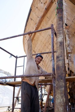 Hintli ve Bengalli işçiler, 13.10.2014 tarihinde Dubai, BAE 'de eski ahşap gemileri ve Dhows teknelerini tamir ediyor.