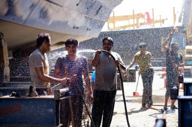 Hintli ve Bengalli işçiler, 13.10.2014 tarihinde Dubai, BAE 'de eski ahşap gemileri ve Dhows teknelerini tamir ediyor.