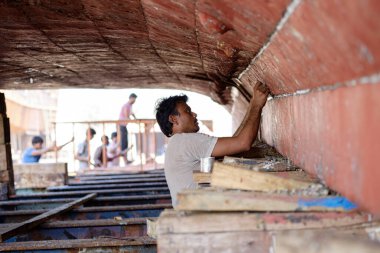 Hintli ve Bengalli işçiler, 13.10.2014 tarihinde Dubai, BAE 'de eski ahşap gemileri ve Dhows teknelerini tamir ediyor.