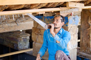 Hintli ve Bengalli işçiler, 13.10.2014 tarihinde Dubai, BAE 'de eski ahşap gemileri ve Dhows teknelerini tamir ediyor.