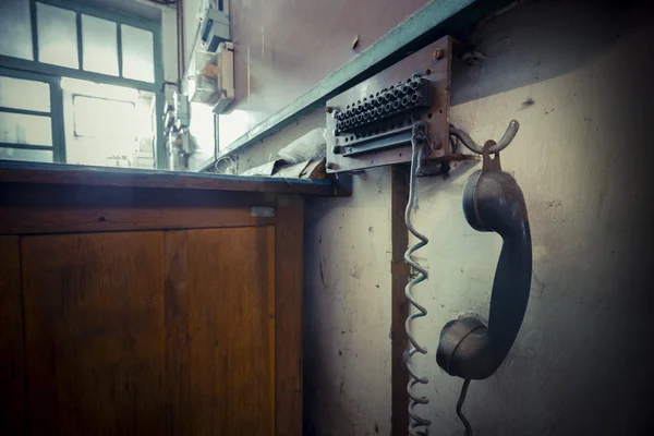 Старый стационарный телефон на заброшенной фабрике — стоковое фото