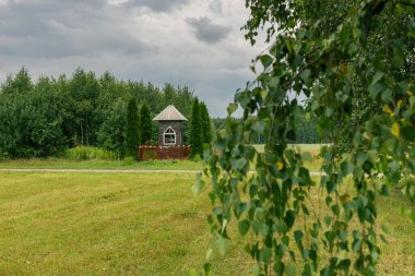 Şehir kilisesinin üzerindeki bulutlar. Birch sokağı. Kırsal alan. Saman hasatından sonra. Yağmurdan önce. Polonya, Mazovia manzarası. Dini gelenekler.