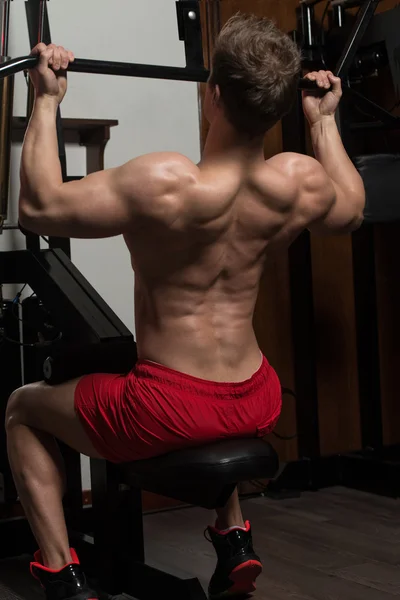 Joven haciendo ejercicio de peso pesado para la espalda — Foto de Stock
