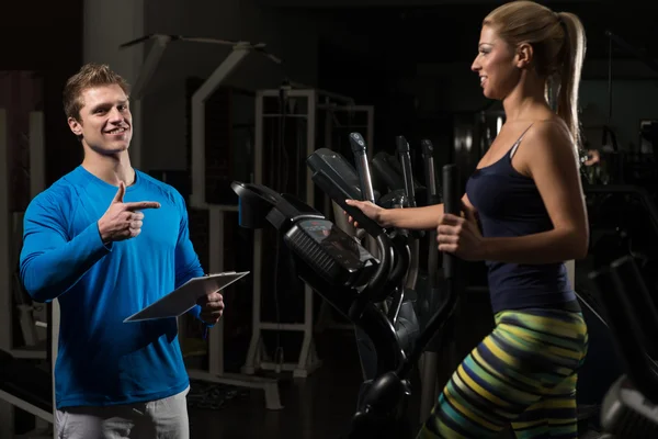 Entraîneur personnel et client en salle de gym — Photo