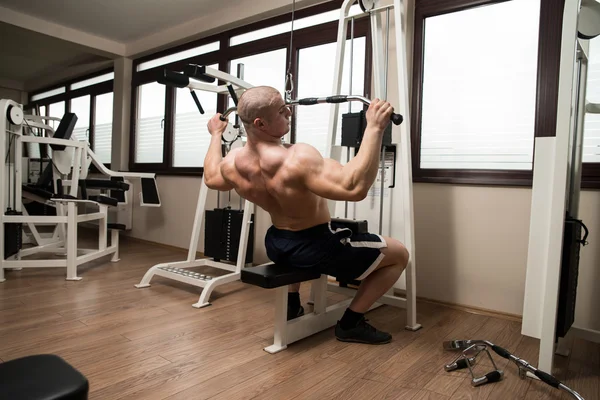 Young Man Doing Back Exercise on a Machine — Stock Photo, Image
