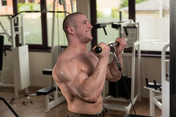 Homme dans la salle de gym faisant de l'exercice Biceps sur la machine — Photo