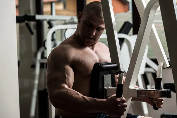 Jeune homme faisant des exercices de dos dans la salle de gym — Photo