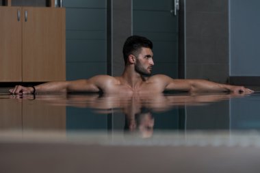Havuzda dinlenen erkek yüzücü