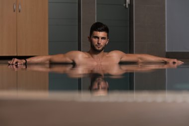 Yüzme Havuzu kenarında oturan adam rahat