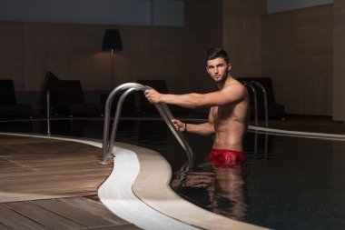 Yüzme Havuzu kenarında oturan adam rahat