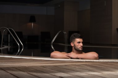 Yüzme Havuzu kenarında oturan adam rahat