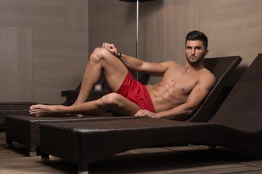 Bir güneşlenme üzerinde yatan genç adam