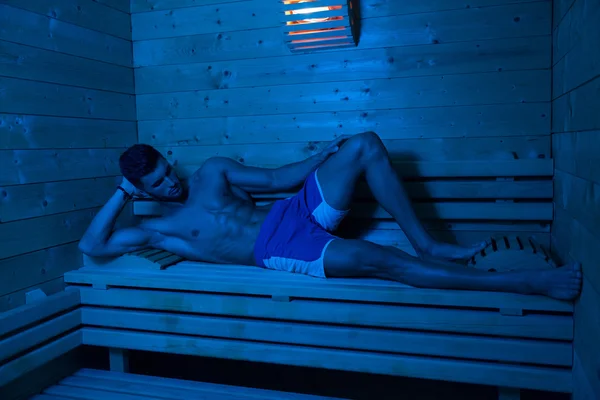 Uomo attraente che riposa rilassato nella sauna — Foto Stock