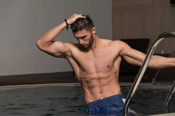 Hombre descansando relajado al borde de la piscina — Foto de Stock