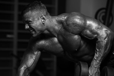 Genç adam geri Dumbbell ile çalışma dışarı