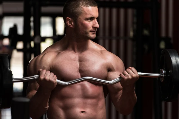 Fisiculturista exercendo bíceps com Barbell — Fotografia de Stock