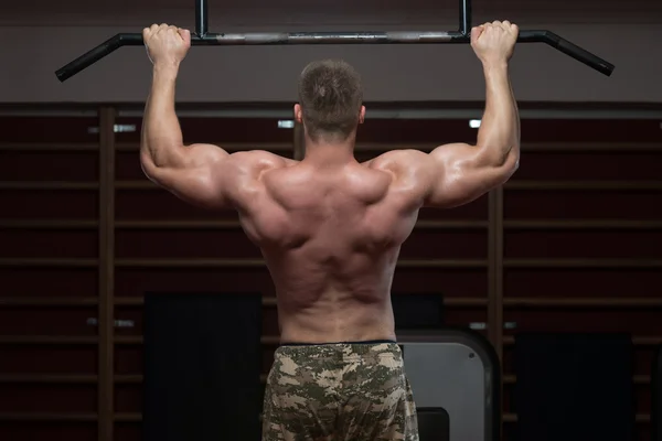 Mužský sportovec dělá pull ups — Stock fotografie