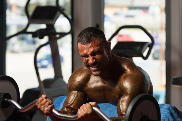 Bodybuilder uitoefening biceps met barbell — Stockfoto