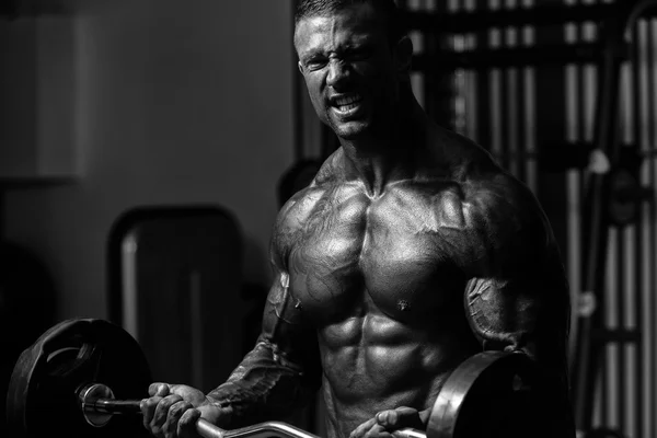 Bodybuilder άσκηση δικέφαλους με Barbell στο γυμναστήριο — Φωτογραφία Αρχείου