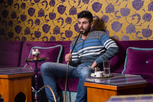 Muž kouření shisha v arabské kavárny — Stock fotografie