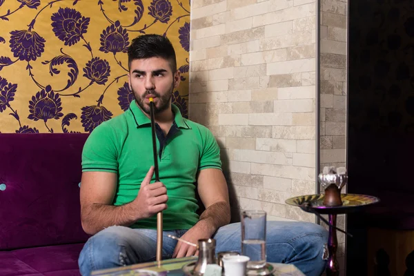 Hombre fumando shisha en el café árabe — Foto de Stock