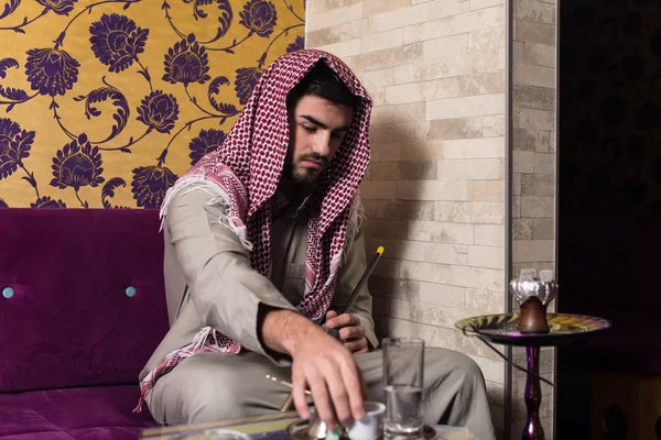 Αραβικά άνθρωπος καπνίζει ναργιλέ και πίνοντας καφέ — Φωτογραφία Αρχείου